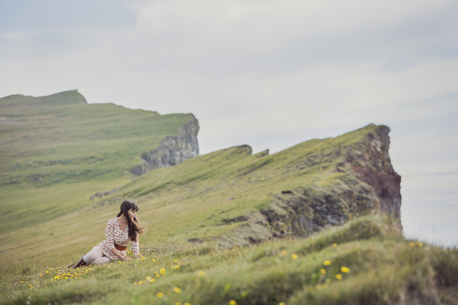 A woman sitting on the ground in a field