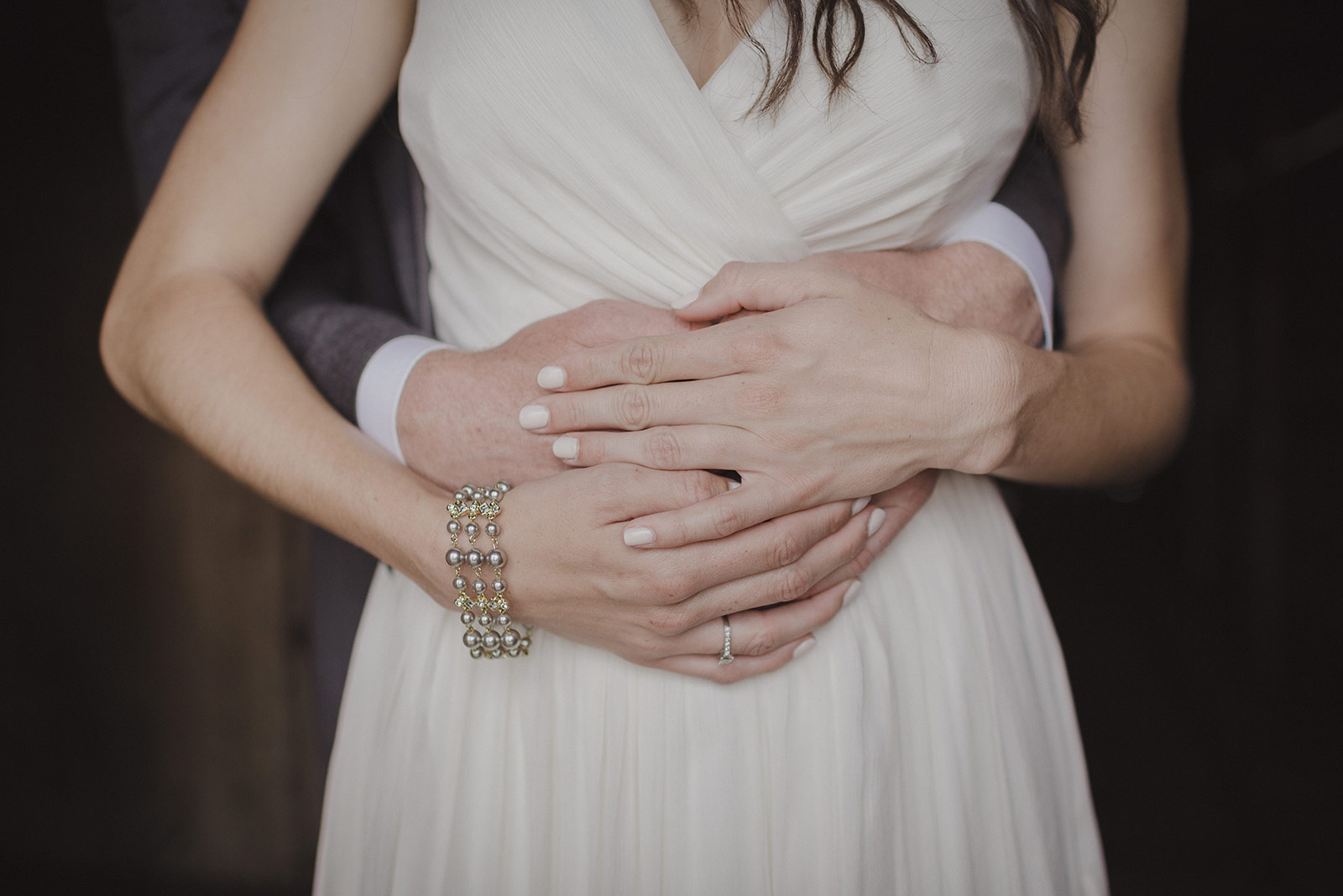 A bride and groom holding hands in front of each other.