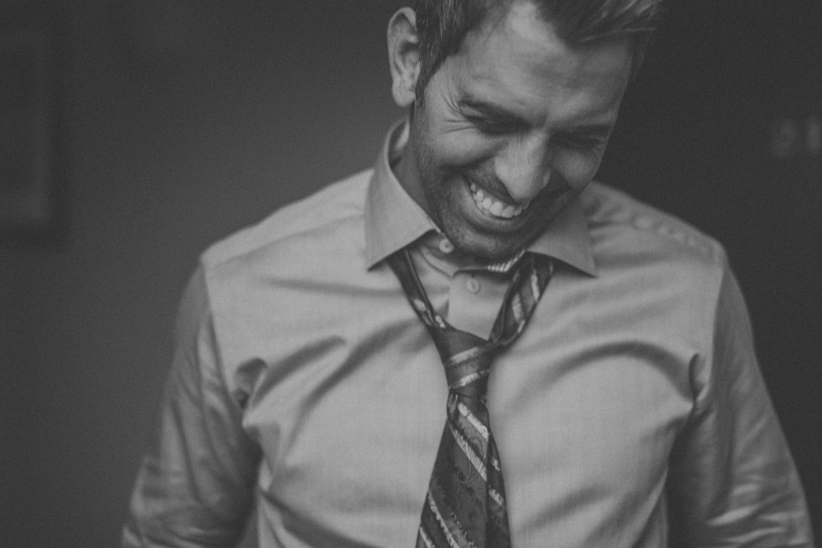 A man in a tie laughing.