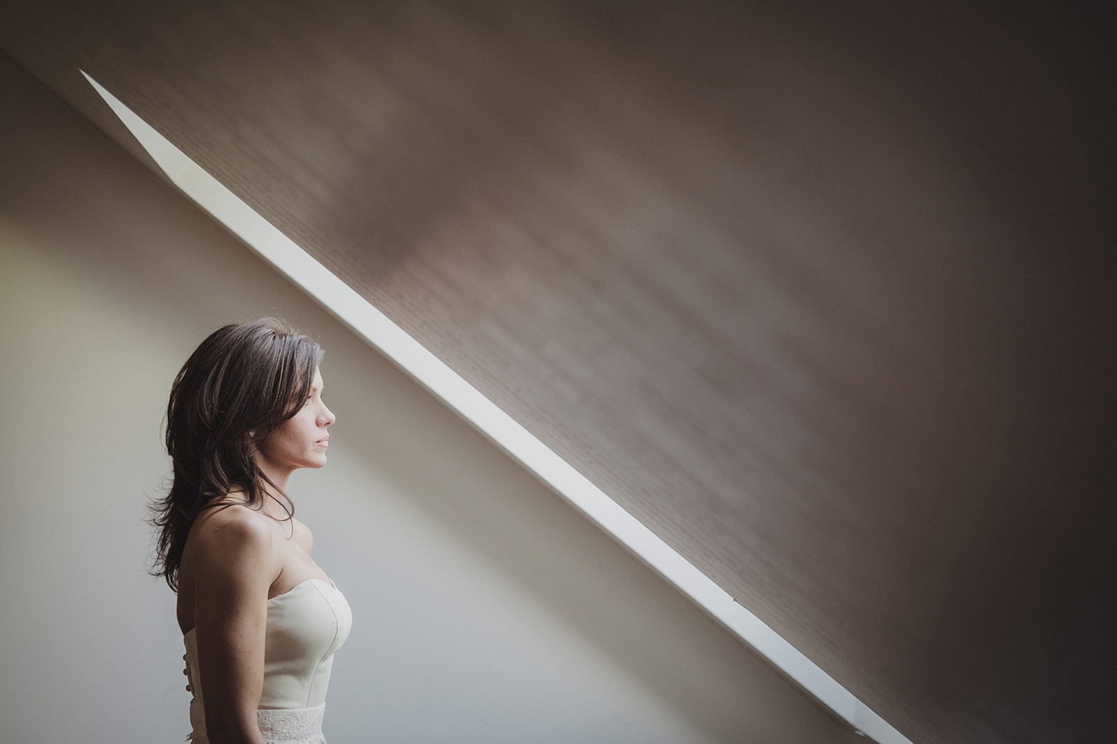 A woman in white dress standing next to stairs.