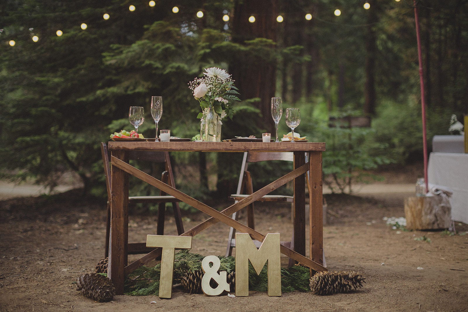 A table with two wooden letters and flowers on it.