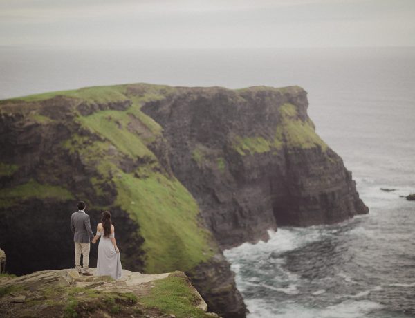 A couple standing on the side of a cliff.